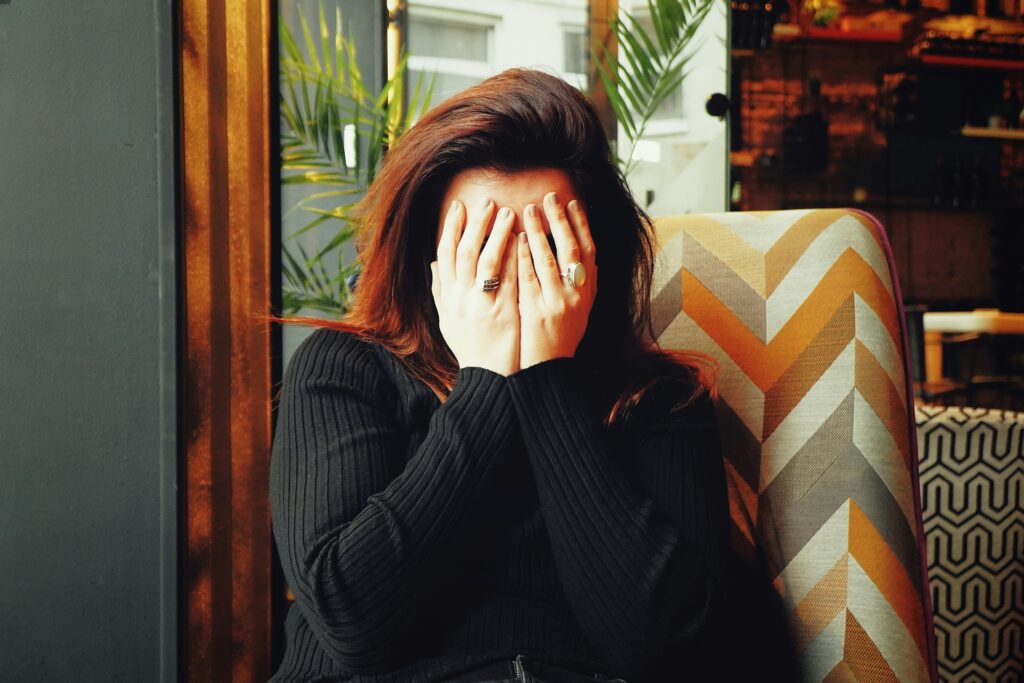 A women hiding her face with her hands